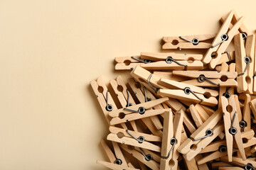 Heap of wooden clothespins on color background