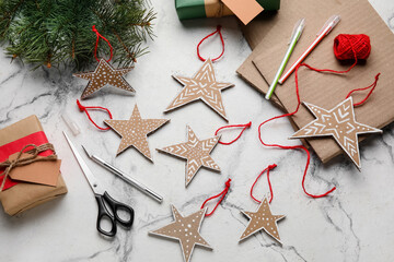 Cardboard stars with Christmas gifts and fir branches on light background