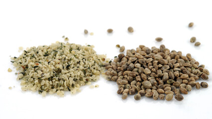 Raw hemp seeds, whole and shelled. Two heaps of raw hemp seeds isolated on a white background. Selective focus..