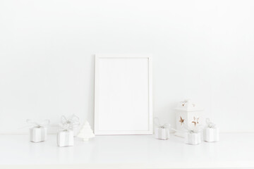 White frame and white gift boxes stand on a white table