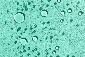 Closeup view of water drops on mint background