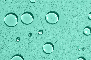 Closeup view of water drops on mint background