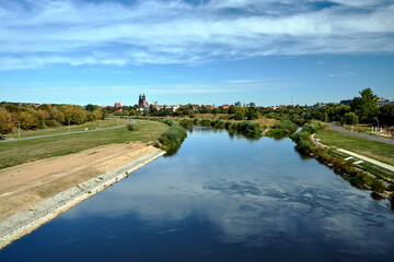 Historic, Gothic buildings and an industrial chimney on the Warta River