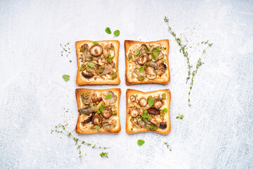 Obraz na płótnie Canvas Delicious toasts with cream cheese, mushrooms and pesto sauce on light background