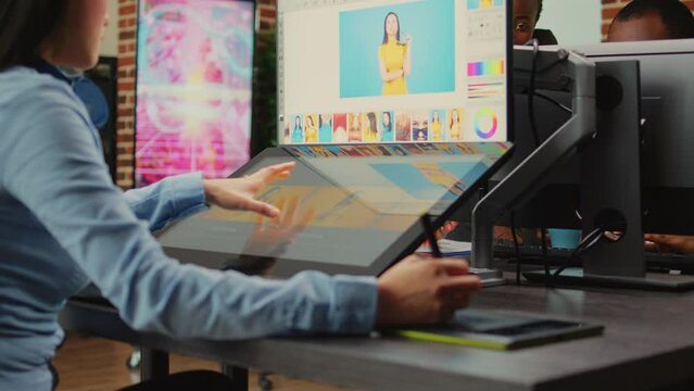 Creative company employee working with touchscreen display to edit photos, using tablet and stylus pen. Photographer editing pictures to create professional content, retouching software.