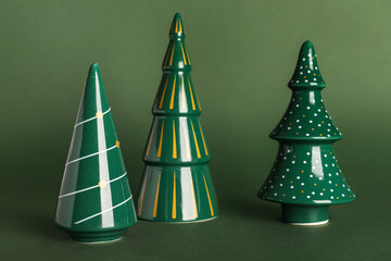 Ceramic Christmas trees on green background