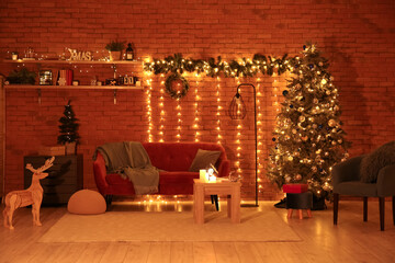 Interior of living room with Christmas trees, sofa and glowing lights at night