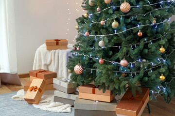 Beautiful Christmas tree with presents and pouf in living room