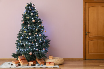 Glowing Christmas tree with presents in living room