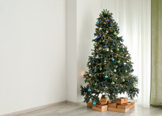 Glowing Christmas tree with presents in living room