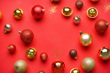 Frame made of Christmas balls and bells on red background