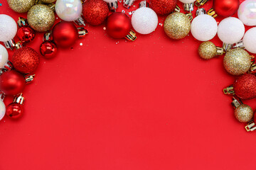 Frame made of beautiful Christmas balls on red background, top view