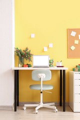 Interior of office with workplace, fir branches in vase and Christmas presents