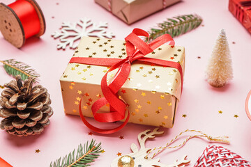 Gift box with Christmas branches on pink background, closeup