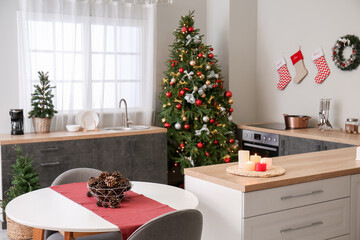 Interior of kitchen with Christmas trees, counters and dining table