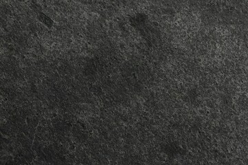 Texture of dark grey stone surface as background, closeup