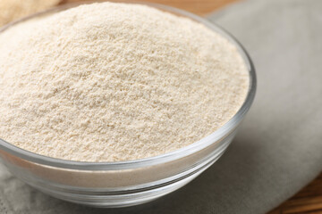 Glass bowl with quinoa flour on table, closeup