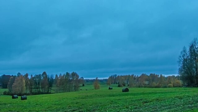 Dark cloudscape roll above green vibrant meadows, fusion time lapse