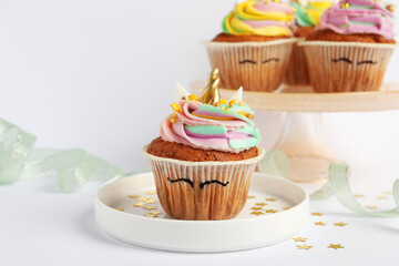 Cute sweet unicorn cupcakes on white table