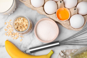 Different ingredients for cooking tasty oatmeal pancakes on white marble table, flat lay