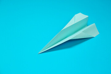 Paper plane on light blue background, space for text