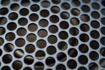 Fragment of the speaker with a metal perforated grille. Speaker texture, blue and black. Macro shot of speaker grille. Vintage effect. Close up shot of Acoustic broadband speaker.