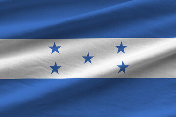 Honduras flag with big folds waving close up under the studio light indoors. The official symbols...