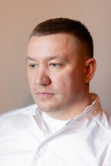 Sad young man on grey background, male loneliness, suffering breakup depression boredom