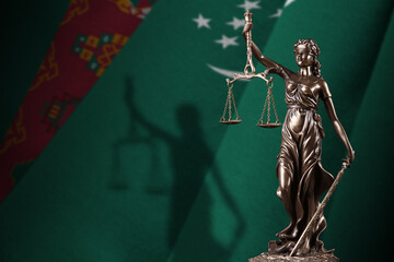 Turkmenistan flag with statue of lady justice and judicial scales in dark room. Concept of...