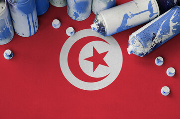 Tunisia flag and few used aerosol spray cans for graffiti painting. Street art culture concept,...