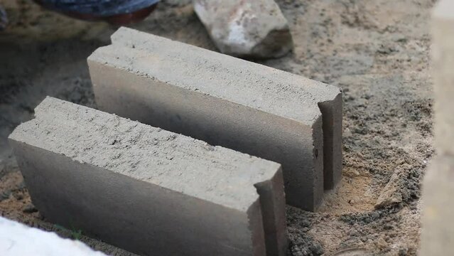 video of the process of making building materials made from a mixture of coarse sand, cement and water, manually using molds made of iron plates.