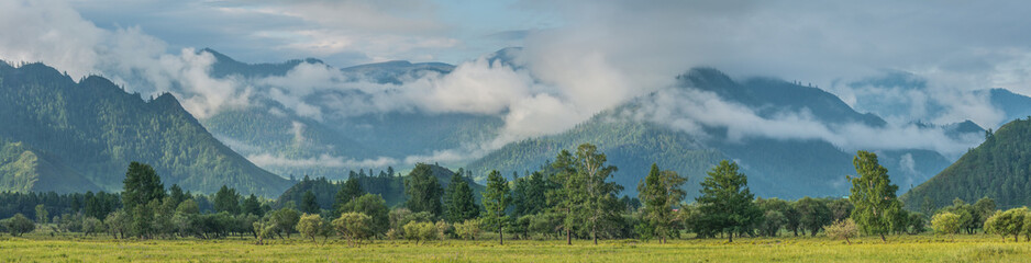 Large panorama of summer mountain landscape, cloudy weather