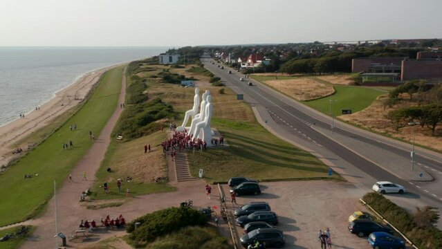 Aerial view of Esbjerg seaside, with slow camera rotation around Man Meets the Sea sculpture. High Angle view of the famous sculpture od with lots of turists visiting. Esbjerg, Denmark
