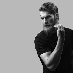 Bearded man with hair brush. Trendy and stylish beard styling and cut. Brutal young bearded man....