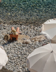 A woman lies on the beach on a sunny day in Nice, France