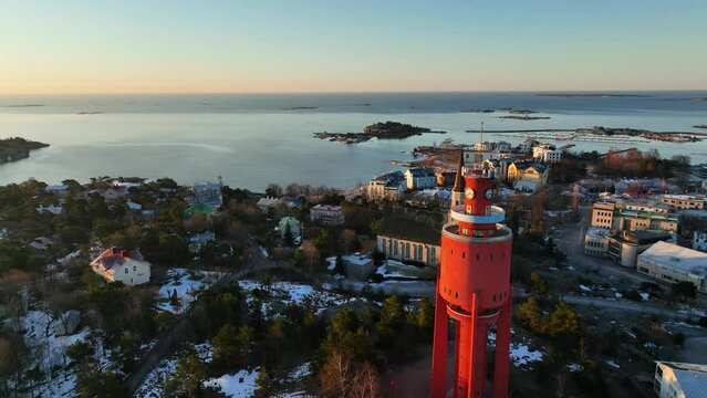 Aerial view overlooking the snowy cityscape of Hanko city, sunrise in Finland - circling, drone shot