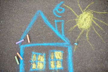Chalk picture of house and sun on asphalt of sidewalk. Kids creative picture on gray background of road. © Maria Sbytova