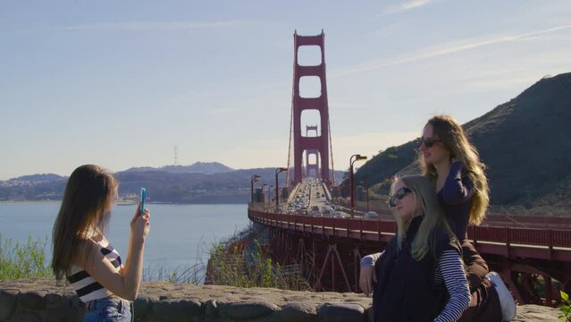 Best female friends enjoying summer holidays in San Francisco city. Close-up view of women taking pictures with iconic landmark behind. High quality 4k footage