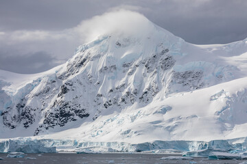 A mountain in Antarctica covered in snow on a bright summer day