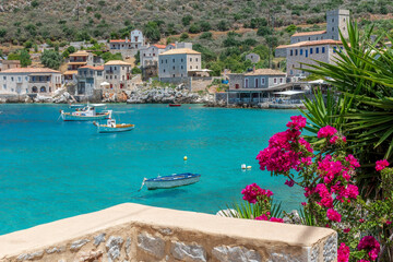 view of  Limeni village with the famous  stone buildings, a blooming bougainvillea, and turquoise waters a as a background  in Mani, South Peloponnese , Greece.