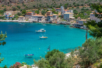 view of  Limeni village with fishing boats in  turquoise waters and the stone buildings as a background  in Mani, South Peloponnese , Greece.