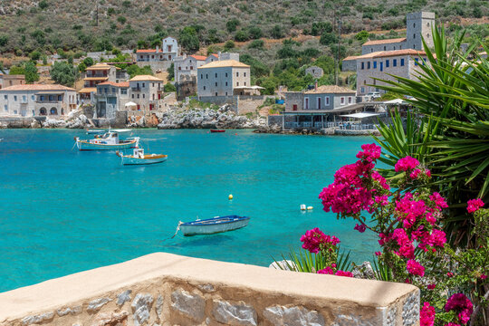 view of  Limeni village with the famous  stone buildings, a blooming bougainvillea, and turquoise waters a as a background  in Mani, South Peloponnese , Greece.