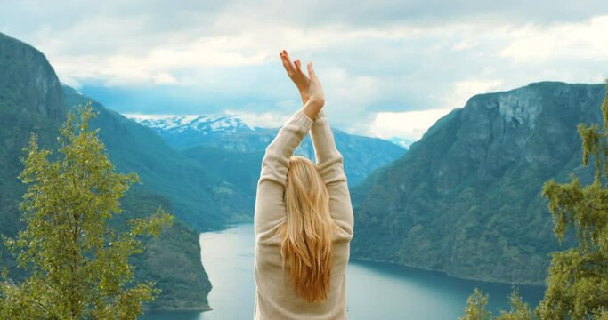 Mountain, landscape and woman stretching in nature for wellness, fitness and health in Norway. Travel, freedom and girl enjoy fresh air, peace and calm on holiday, vacation and adventure with lake
