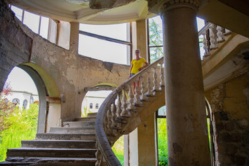 a girl in yellow on the steps of an old staircase