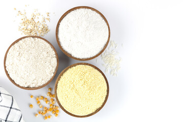 An assortment of alternative, gluten-free flours. Baking ingredients background: gluten free rice, corn, oatmeal on a white background. Copy space, top view. 