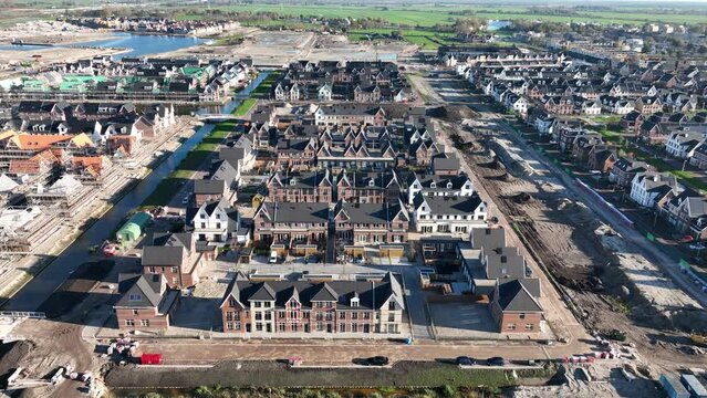 Building and construction of modern suburb housing. Scaffolding residential properties exterior urban development project. Houses in the Netherlands. Aerial drone view.