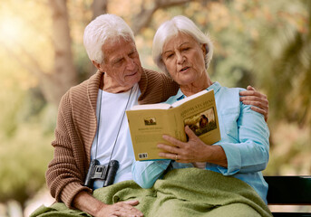 Park, senior and couple reading a book, relaxing and bonding outdoors with blanket. Love,...