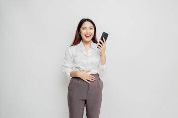 Fototapeta premium Photo of a hungry excited young woman holding her phone and wondering what to order yummy food isolated on white color background