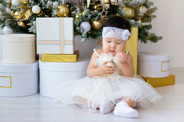 A little Asian girl decorates the Christmas tree.