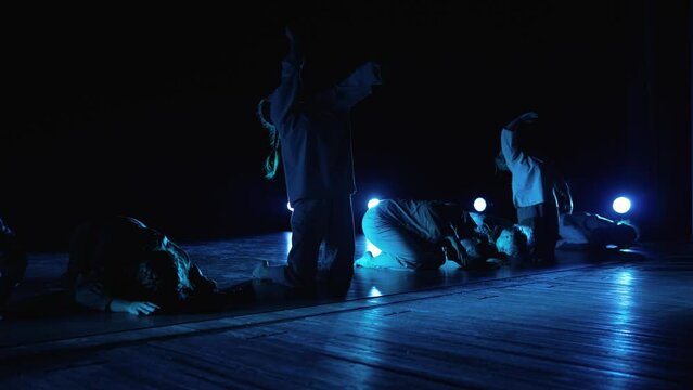 Modern ballet performed by seven dancers. Girls synchronously perform dance elements. The actresses act out a modern lyrical performance. Girls synchronously perform an element of dance on the stage.